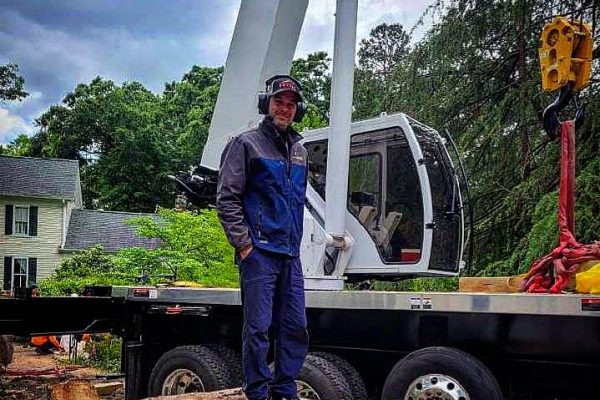 a man in front of a white truck with a crane